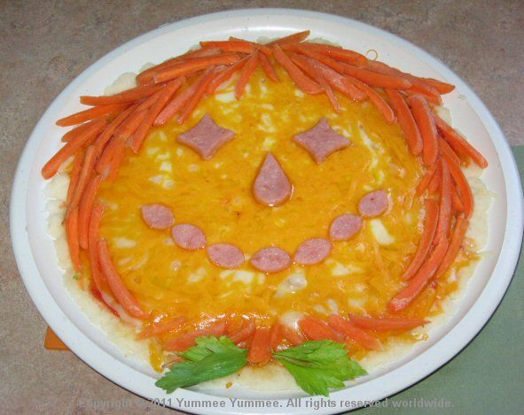 A scarecrow with carrot hair makes a fun and tasty Halloween pizza.